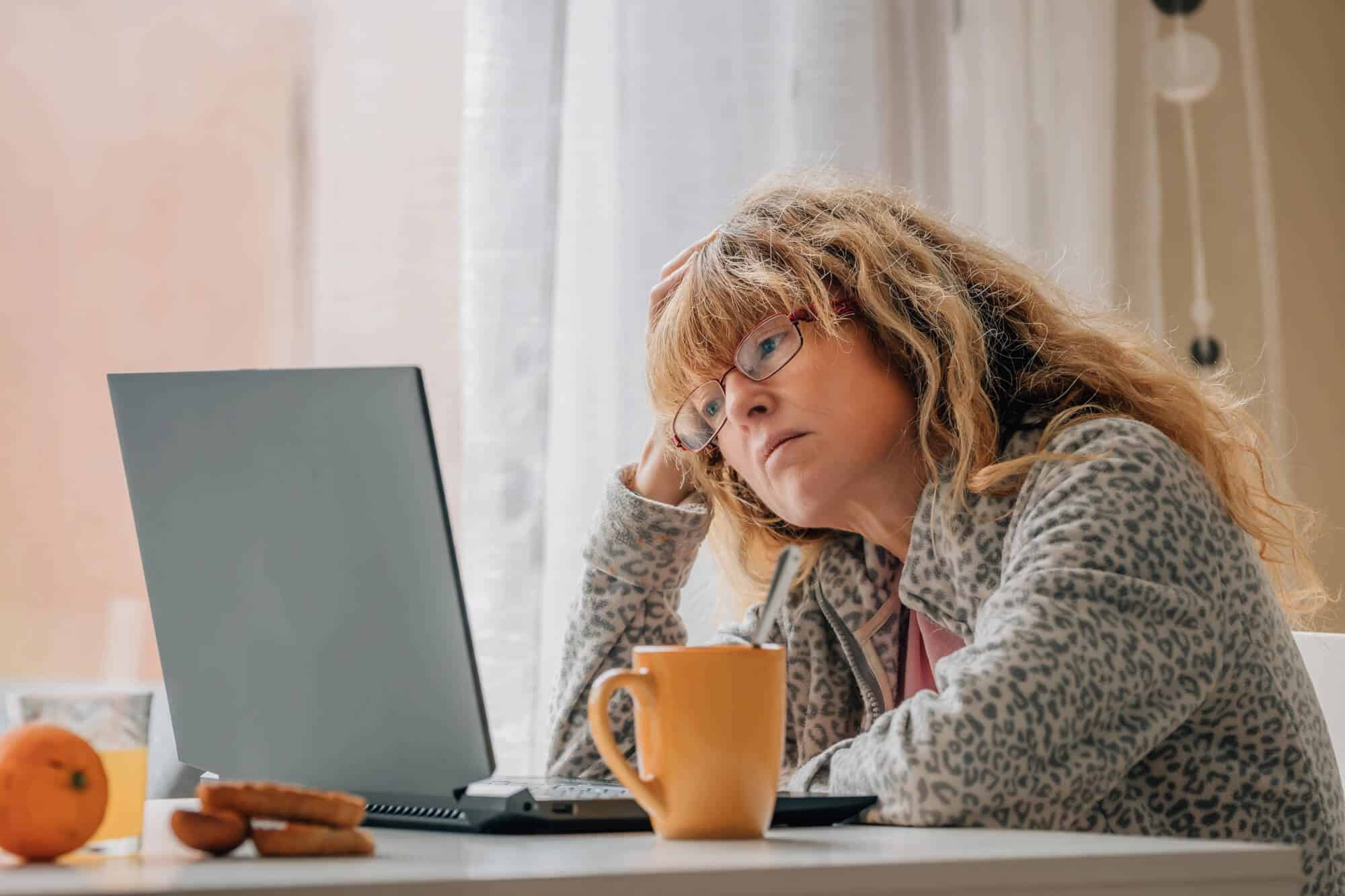 woman at laptop looking fed up