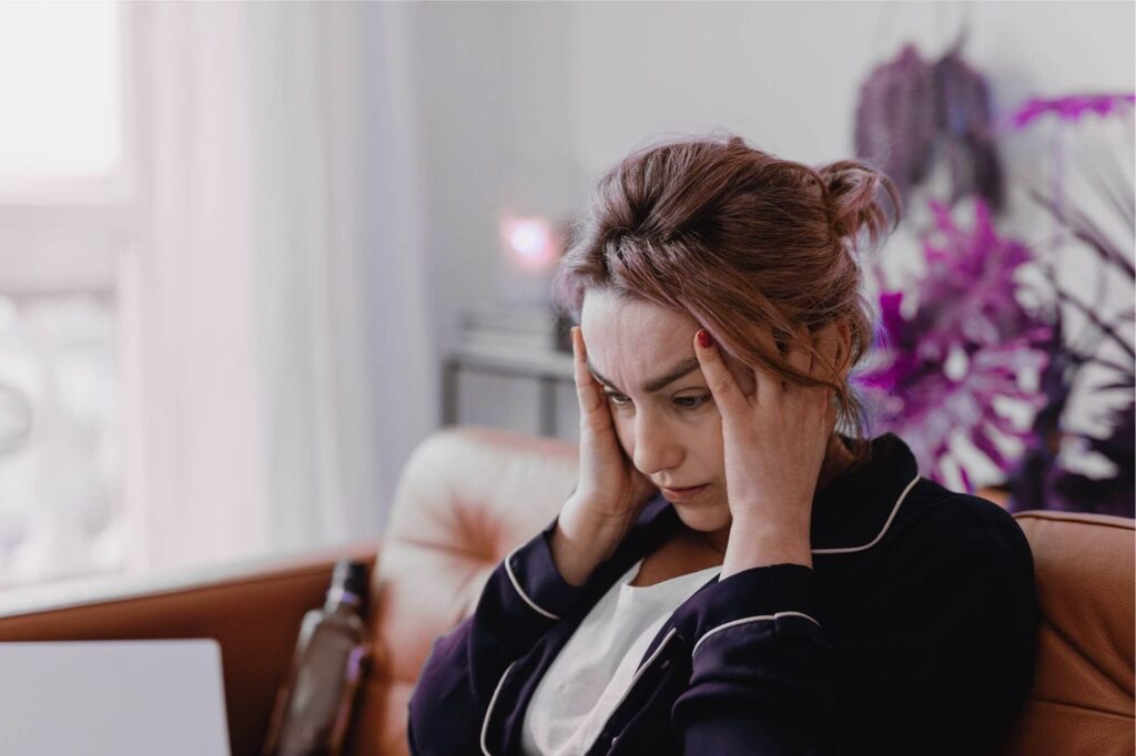 stressed woman at laptop in her PJs