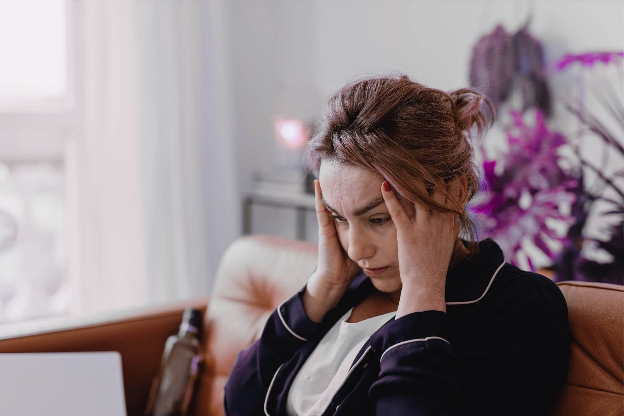 stressed woman at laptop in her PJs