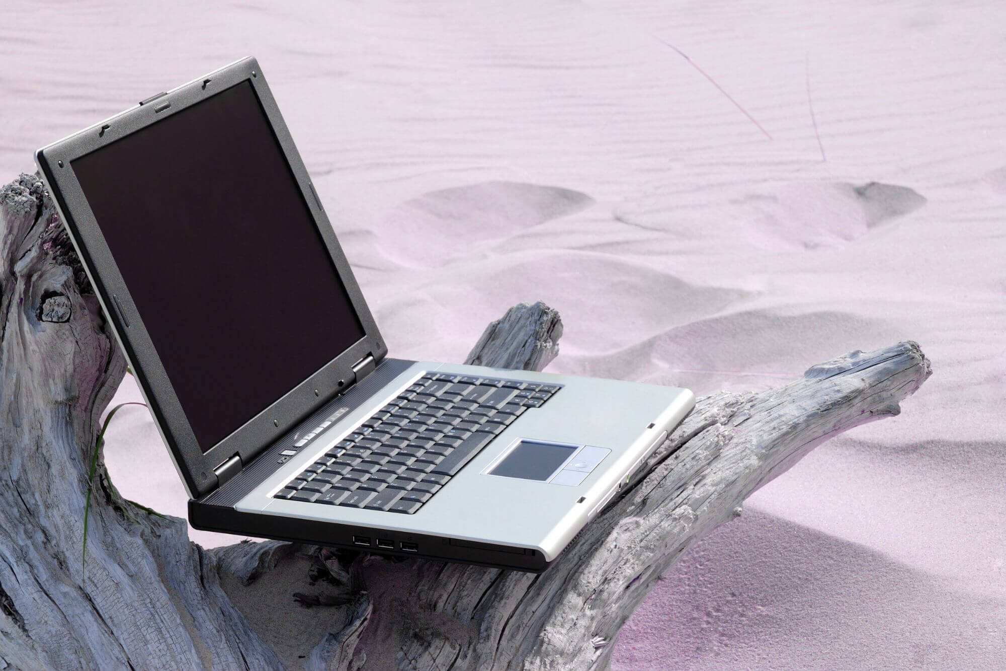 laptop all alone on sand